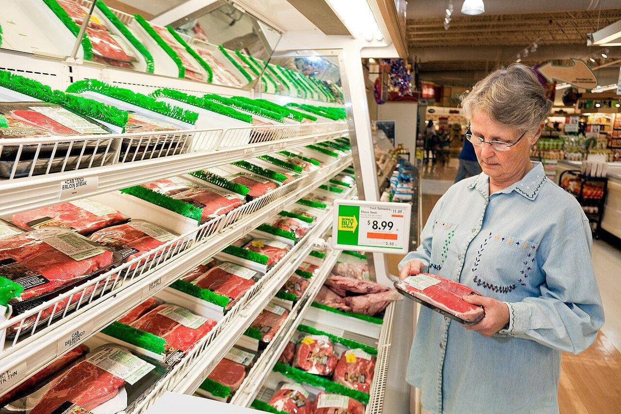 A shopper inspects a package of meat at an American grocery store, in a Department of Agriculture photograph from 2012.