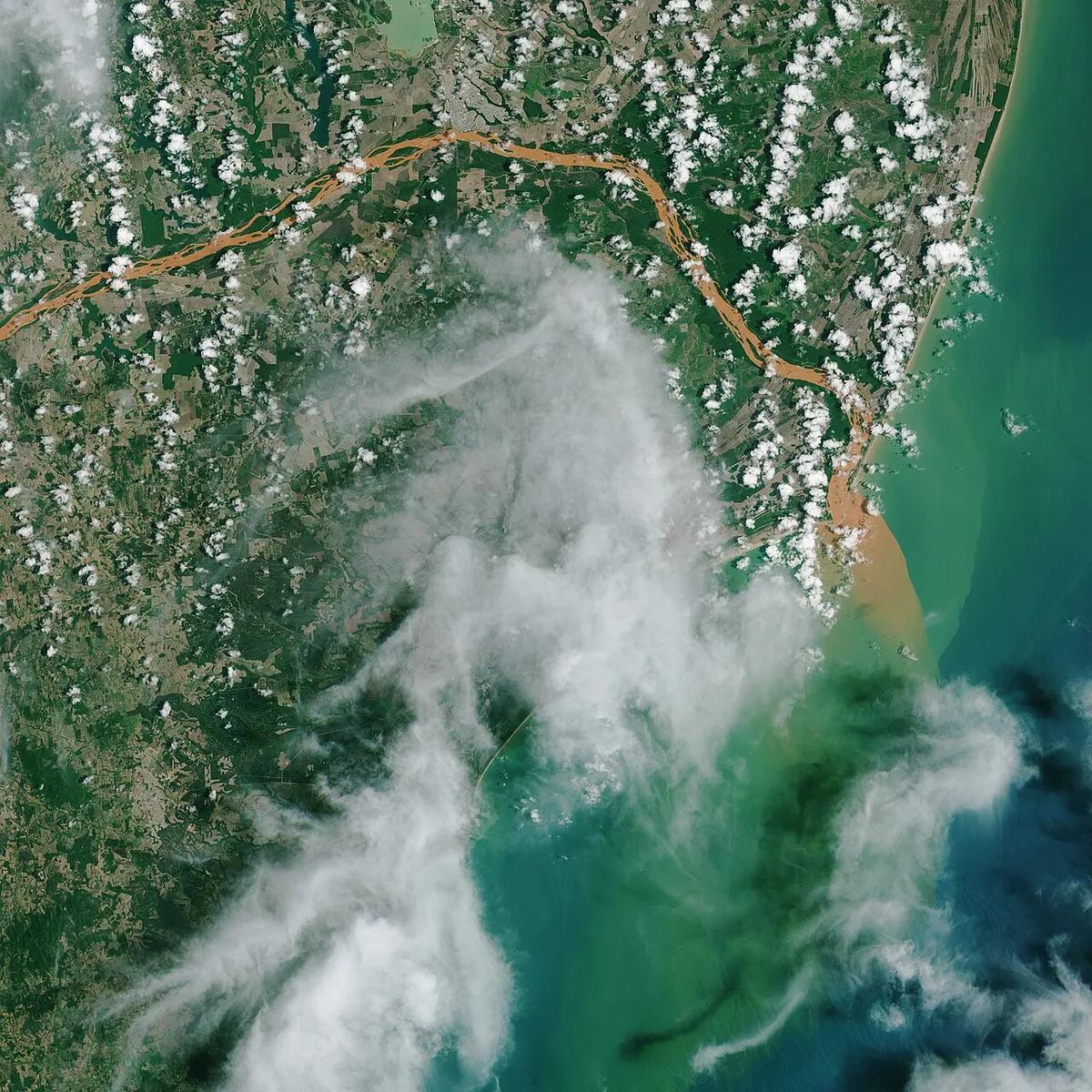 Una imagen de satélite de la NASA muestra la pluma de residuos del colapso de la represa de Fundão llegando al Atlántico por la desembocadura del río Doce, a fines de 2015.